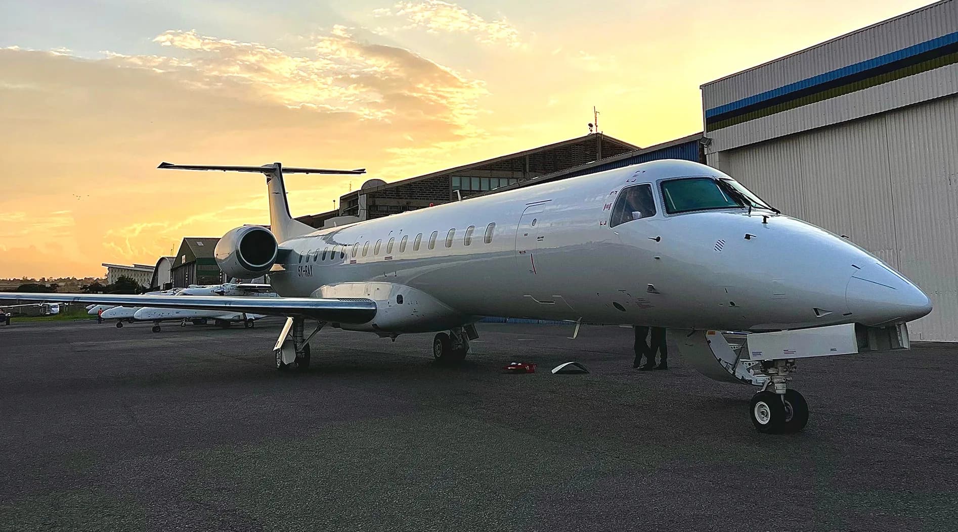 ALS ERJ-145 LR 5Y-RAY, plain white, outside the hangars at Wilson Airport at sunset
