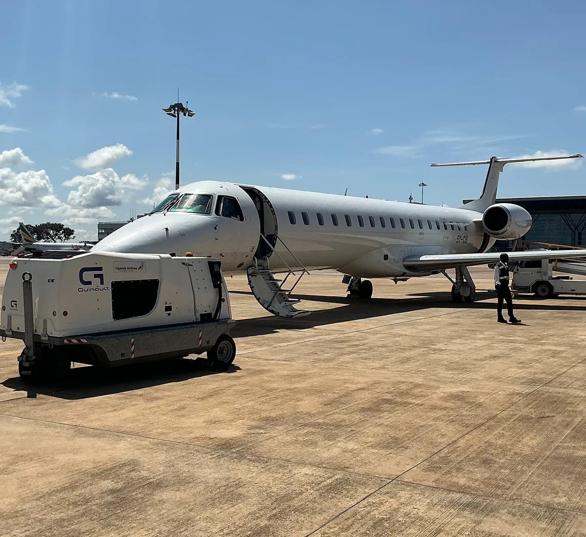 ALS Embraer ERJ-145 on a sunlit apron with its airstairs down and a ground power unit at the nose