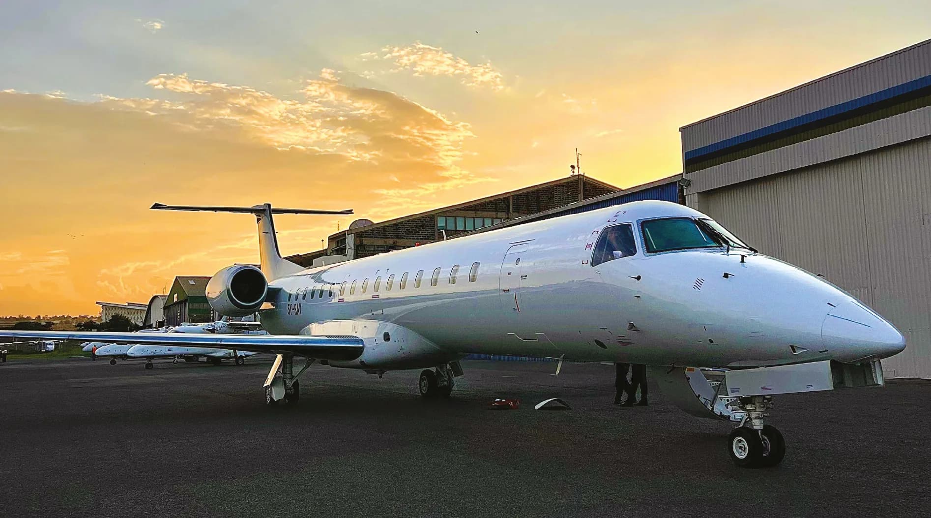 ALS Embraer ERJ-145 outside a hangar at dusk