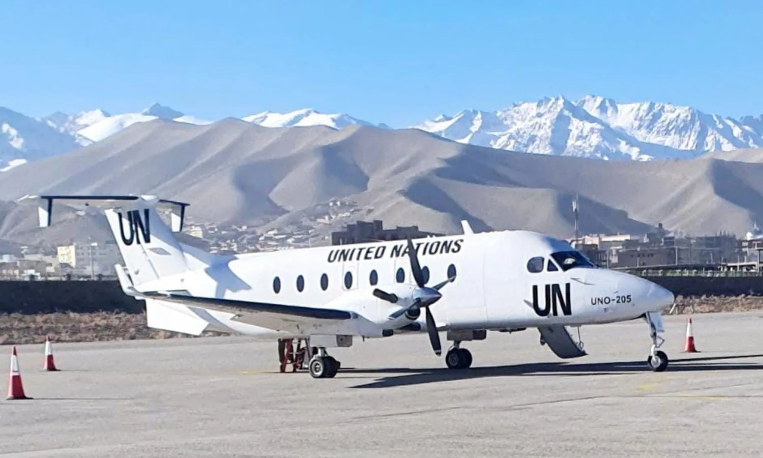 Beechcraft 1900D in United Nations markings below snow-capped mountains
