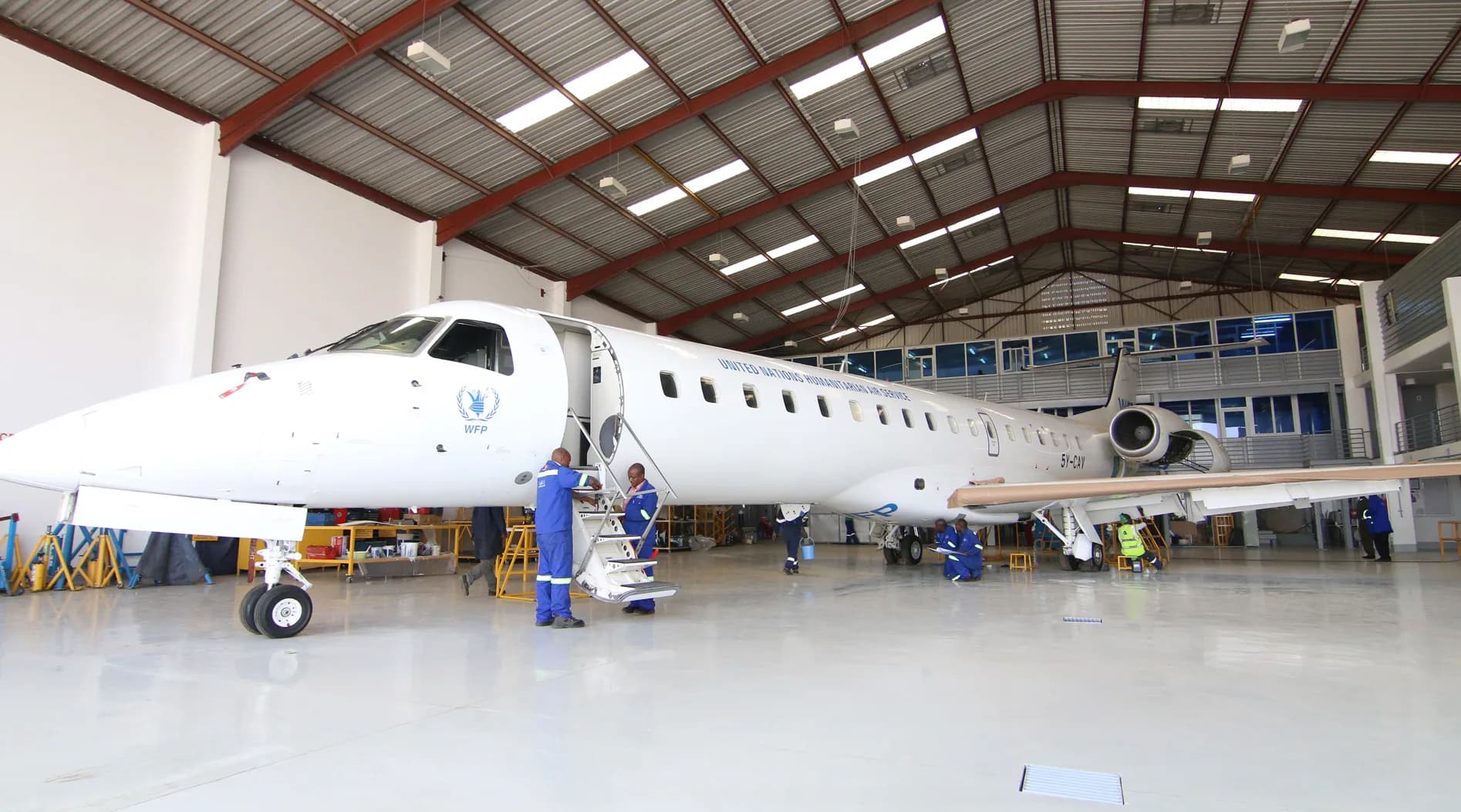 An Embraer ERJ-145 in the ALS hangar at Wilson Airport, engineers at the door