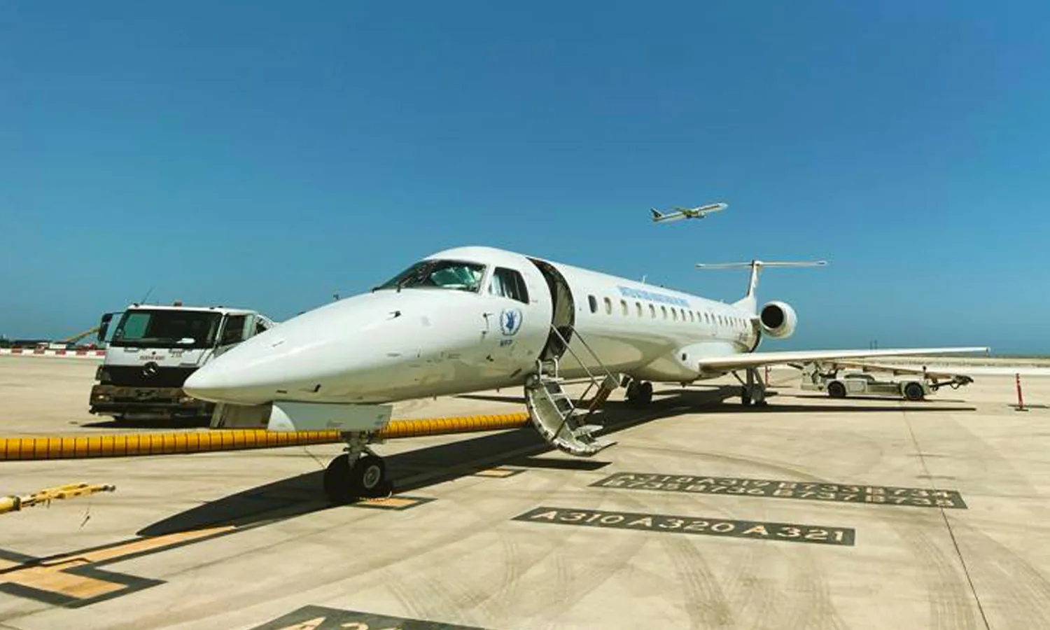 An Embraer ERJ-145 with WFP titles on the apron, airstairs down