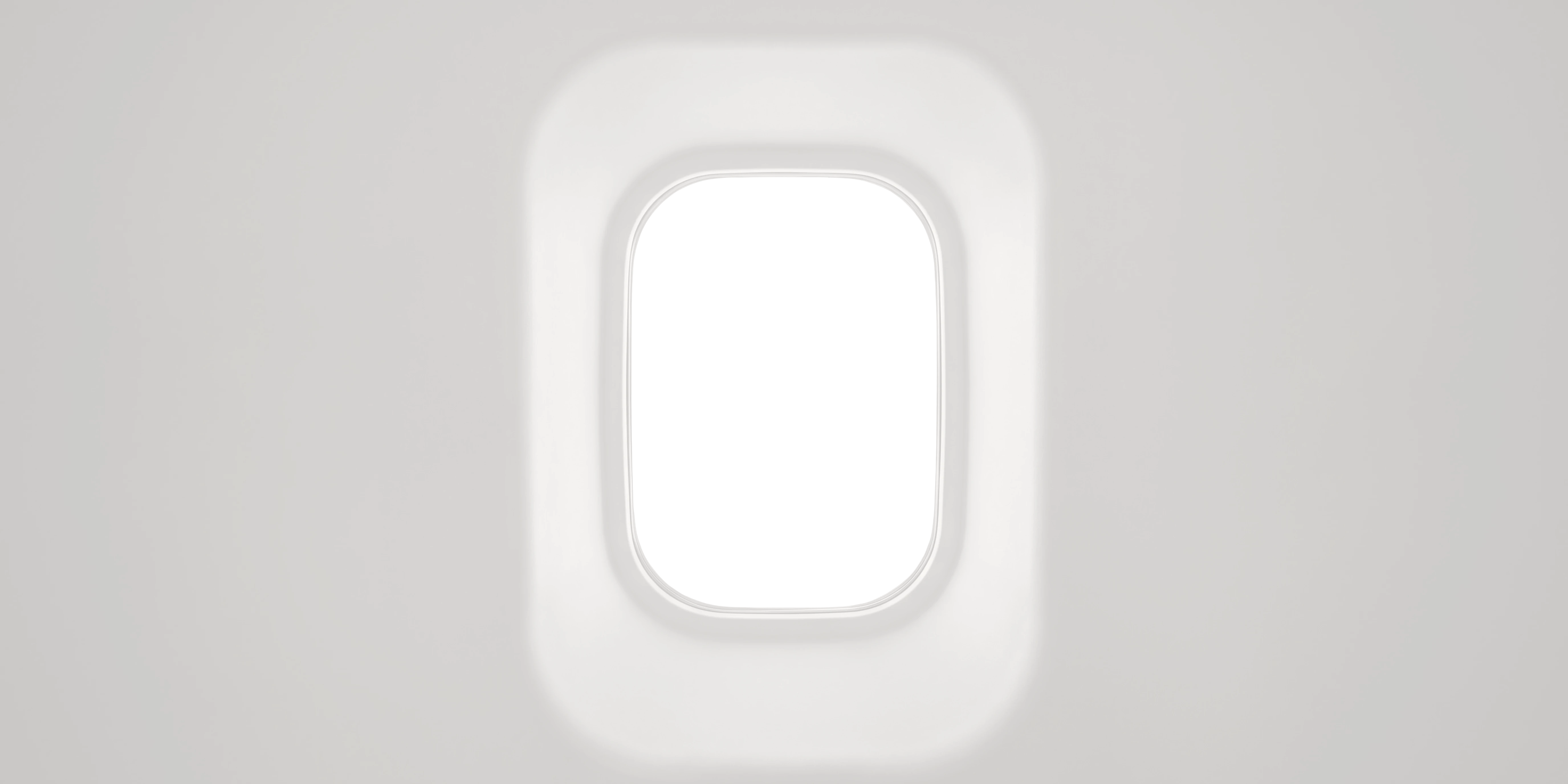 An aircraft cabin window, looking out over the wing